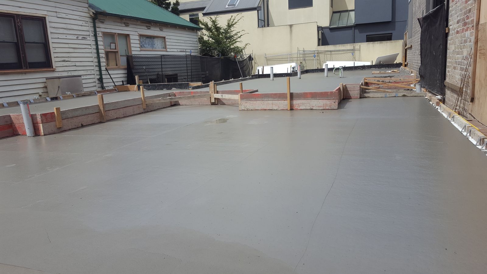 Freshly finished concrete slab with formwork around the edge