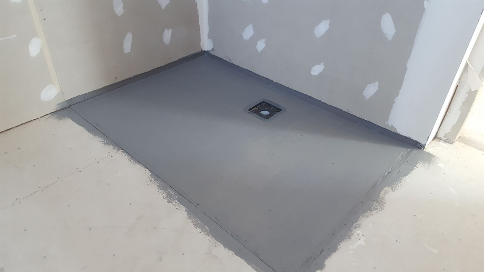 Shower floor substrate with the waste sealed, before waterproofing and tiling