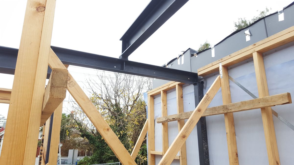 Structural steel beams meeting the timber wall frames